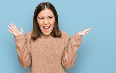 Canvas Print - Young beautiful woman wearing casual clothes celebrating crazy and amazed for success with arms raised and open eyes screaming excited. winner concept