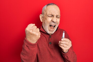 Sticker - Handsome mature man holding spark plug annoyed and frustrated shouting with anger, yelling crazy with anger and hand raised