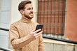 © Krakenimages.com - Young caucasian man smiling happy using smartphone at the city.