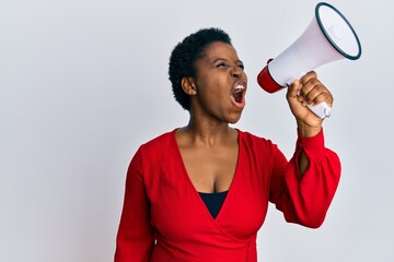 Wall Mural - Young african american woman screaming angry using megaphone over isolated white background.