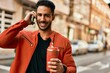 © Krakenimages.com - Young hispanic man talking on the smartphone drinking coffee at the city.