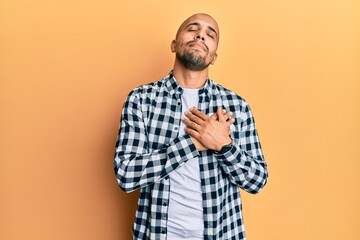 Poster - Hispanic adult man wearing casual clothes smiling with hands on chest, eyes closed with grateful gesture on face. health concept.