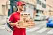© Krakenimages.com - Young caucasian deliveryman smiling happy holding delivery food at the city.