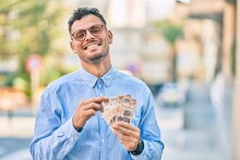 Young Hispanic Businessman Smiling Happy Counting Mexican 500 Pesos Banknotes At The City.