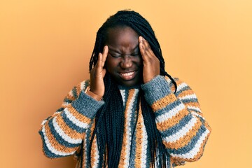 Wall Mural - Young black woman with braids wearing casual winter sweater with hand on head, headache because stress. suffering migraine.