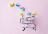 Fototapeta Mapy - Miniature trolley on a pink background, business concept