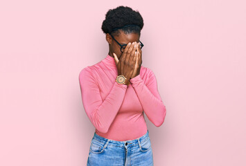 Wall Mural - Young african american girl wearing casual clothes and glasses with sad expression covering face with hands while crying. depression concept.