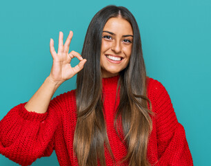 Sticker - Beautiful hispanic woman wearing casual clothes smiling positive doing ok sign with hand and fingers. successful expression.