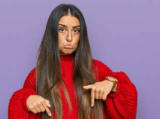 Canvas Print - Beautiful hispanic woman wearing casual clothes pointing down looking sad and upset, indicating direction with fingers, unhappy and depressed.