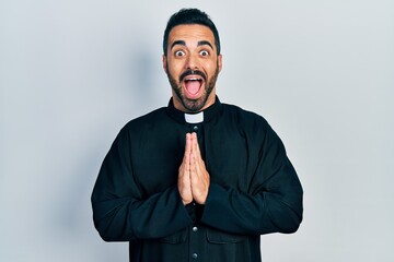 Poster - Handsome hispanic priest man with beard standing over isolated background celebrating crazy and amazed for success with open eyes screaming excited.