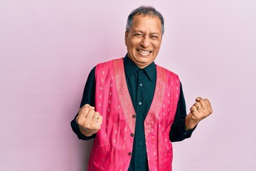 Poster - Middle age indian man wearing traditional indian clothes excited for success with arms raised and eyes closed celebrating victory smiling. winner concept.