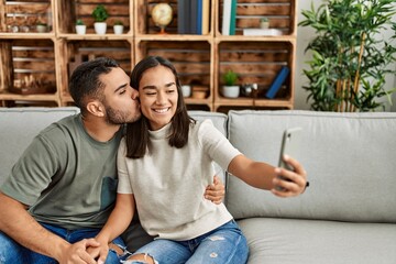 Wall Mural - Young latin couple smiling happy making selfie by the smartphone at home.