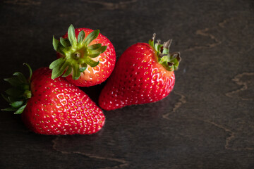 A close up of strawberries on a wooden table.