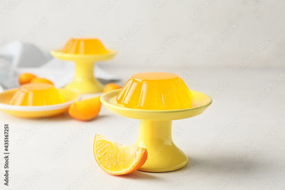 Dessert stand with tasty orange jelly on white background