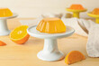 Dessert stand with tasty orange jelly on light wooden background