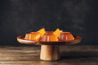 Dessert stand with tasty orange jelly on dark wooden background