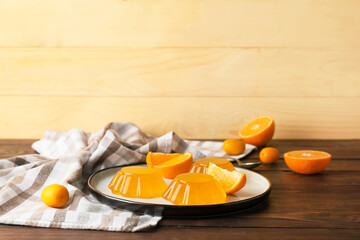 Wall Mural - Plate with tasty orange jelly on wooden background