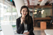 © amnaj - Beautiful businesswoman sitting at a modern office holding a smartphone. Looking at the camera.