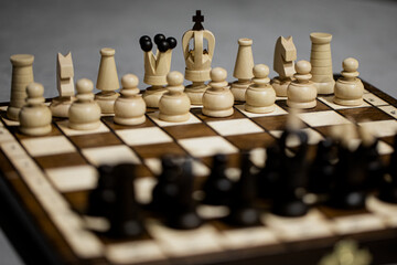 Wooden Chess pieces on board, arranged in incorrect initial position selective focus. White king is not in his cell. Children's formation error, chess for beginners. first chess lesson arrange pieces