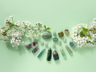 Canvas Print - Gemstones minerals set of green colors and white flowers on green background. Healing stones for Crystal Ritual, Esoteric spiritual practice. modern wicca magic. flat lay