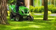 Professional Worker Trimming Green Grass With Lawn Mower M Tractor In The Park.