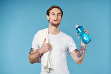 sporty man showing thumb up water bottle towel on shoulder cropped view blue background