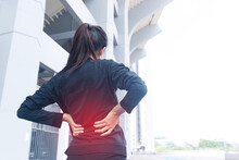 Woman Athlete Runner With Back Pain Injury During Training With Hand Holding With Back. Overtrained Injured. Twist Sprain And Cramp Or Injury Accident Concept. Body Ache Concept. Muscle Ache Concept.