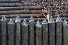 A Protective Fence Made Of Logs With Sharp Upper Ends, Used In Ancient Russia To Protect Against Enemies. Traditional Old Russian Wooden Construction Of Houses.