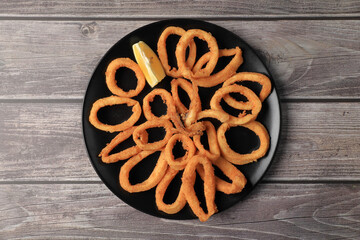 Wall Mural - Ration of squid a la romana (Andalusian frying) on wooden table