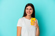 © Asier - Young caucasian woman holding a mobile phone isolated on blue background looks aside smiling, cheerful and pleasant.