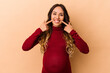 © Asier - Young mexican pregnant woman isolated on beige background smiles, pointing fingers at mouth.