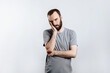 © Daria Lukoiko - Portrait of handsome young man frowning while holding hands near head on white background with space for advertising mock up