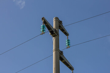 Electric pole and Power lines with blue sky in background.