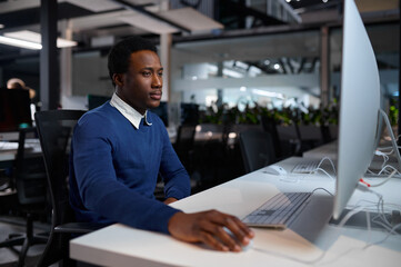 Man in glasses works on computer, office lifestyle