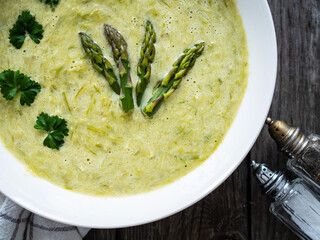 Cream asparagus soup on wooden table
