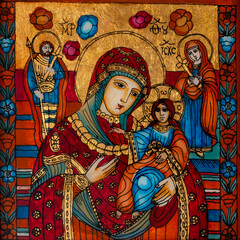 Icon painted on reverse glass in the naive orthodox style of Eastern Europe depicting Virgin Mary and baby Jesus.