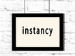 © iushakovsky - Black frame hanging on white brick wall with inscription instancy