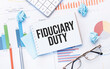 Notepad with text fiduciary duty on the business charts and pen,business