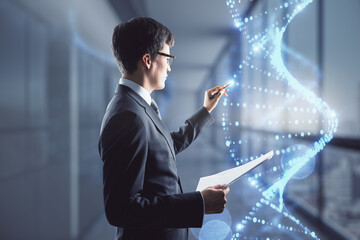 Wall Mural - Bioengineering concept with man in black suit writing on virtual dna strand.