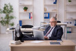 © Elnur - Old male employee sitting at workplace