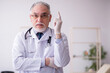 © Elnur - Old male doctor working in the clinic