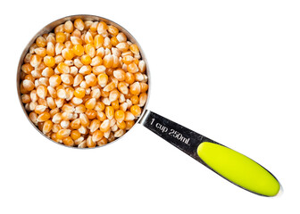 Wall Mural - raw maize (corn) seeds in measuring cup cutout