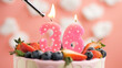 Birthday cake number 36, pink candle on beautiful cake with berries and lighter with fire against background of white clouds and pink sky. Close-up