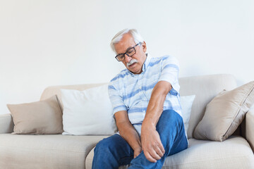 Wall Mural - Pain in the leg of an elderly man. Senior man holding painful muscle, sprain or cramp ache