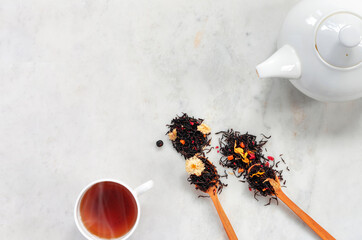 White teapot and two cups of hot drink on on marble countertop . Dry fermented tea made from leaves, flowers, berries and herbs.