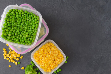 Plastic containers with vegetables on dark background