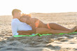 © GiuseppeElioCammarat - multiracial happy couple on the beach, lying top each other