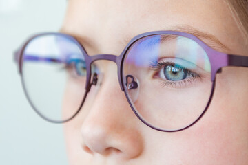 Health care, eyeball check, clear vision concept. Close up portrait of pensive schoolgirl in new glasses