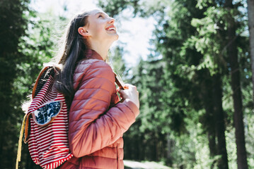 Pretty teen young tourist girl relaxing on forests road.Teenage with backpack on green forest summer or spring.Closeup.