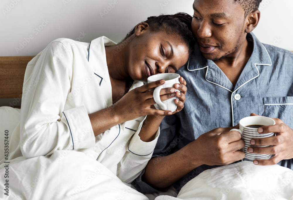 A couple having coffee in bed - obrazy, fototapety, plakaty 